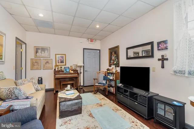 a living room with furniture a flat screen tv and a fireplace