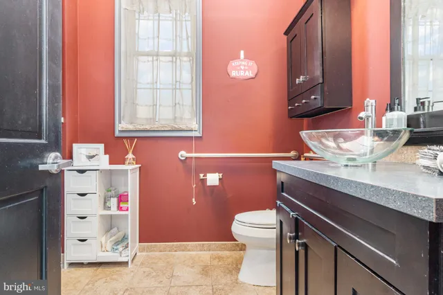 a bathroom with a granite countertop toilet sink and mirror