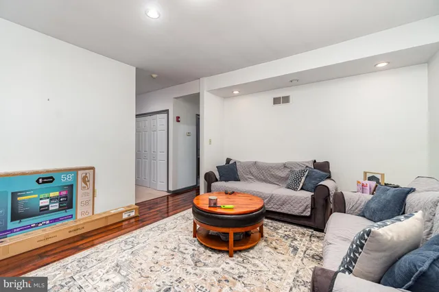 a living room with furniture and a wooden floor