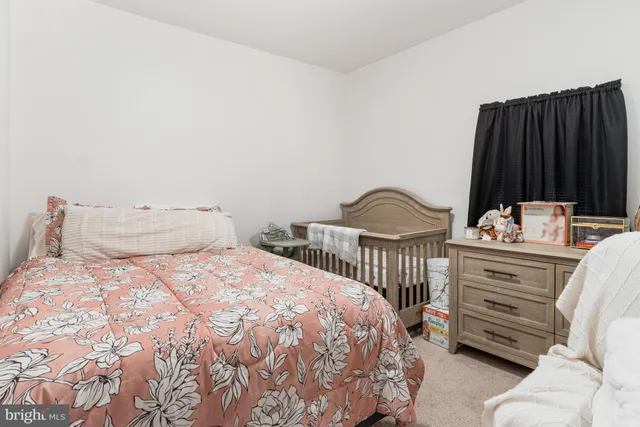 a bedroom with a bed a dresser and window