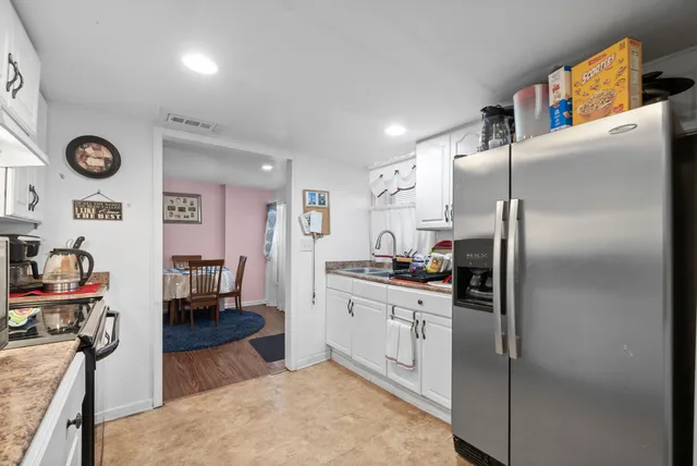 a kitchen with stainless steel appliances granite countertop a refrigerator a stove and a sink