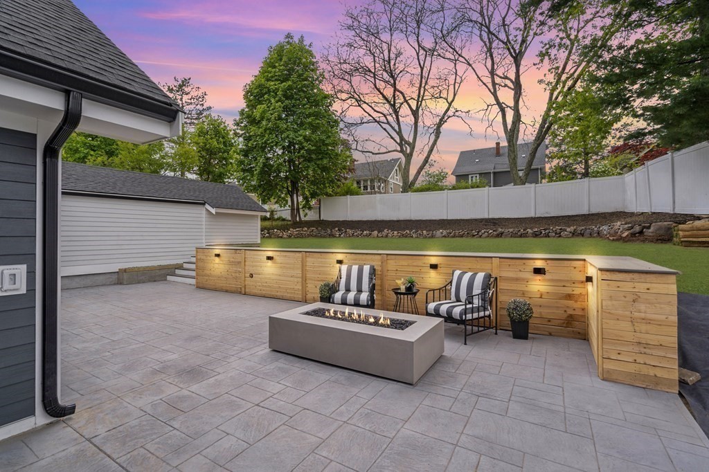 a view of a patio with table and chairs with wooden fence and plants