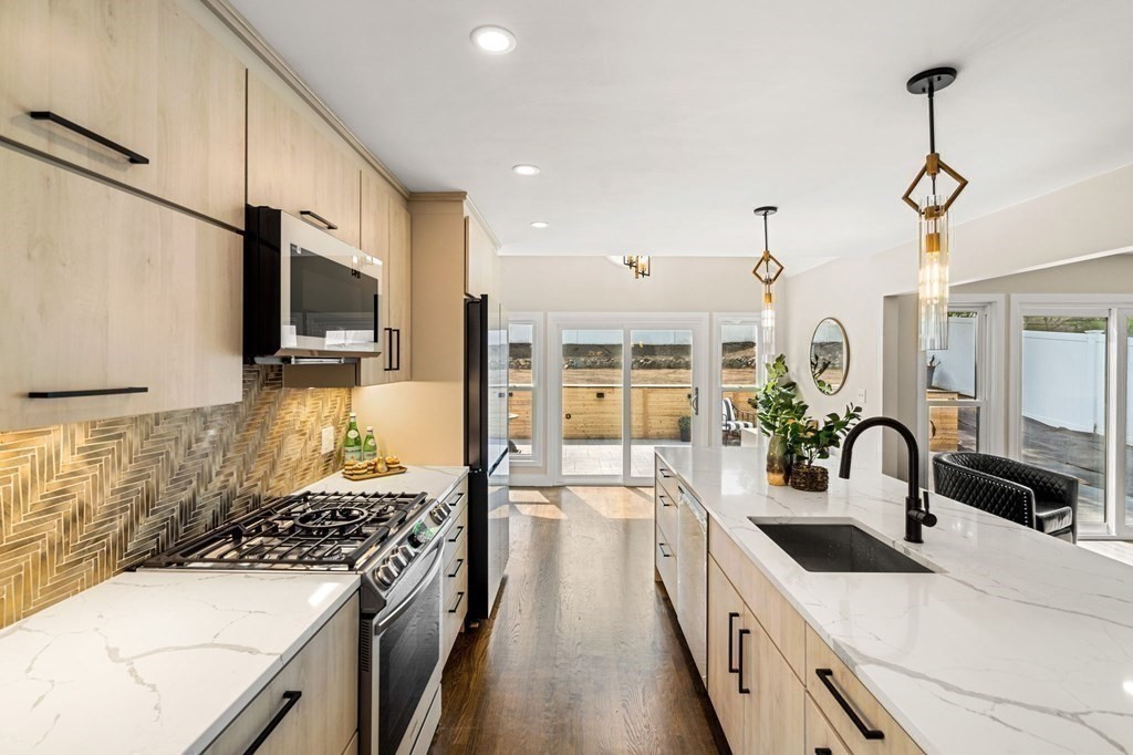 84 School Street Melrose, MA 02176 - Photo 13 of 34 a kitchen with stainless steel appliances a sink stove and cabinets