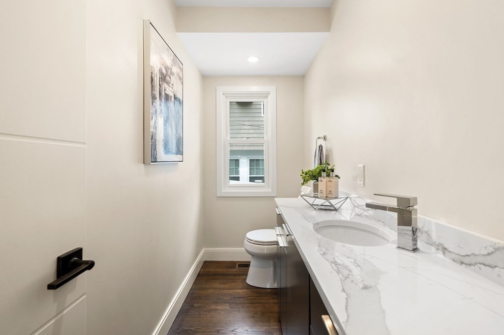 84 School Street Melrose, MA 02176 - Photo 18 of 34 a bathroom with a granite countertop sink a toilet and a mirror