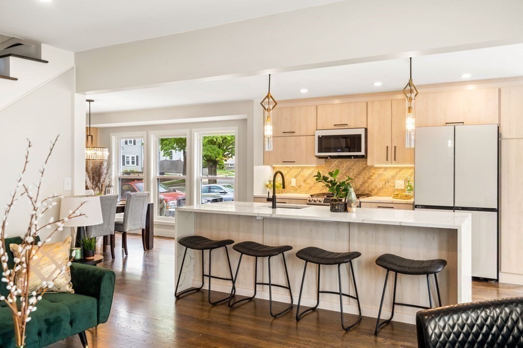 84 School Street Melrose, MA 02176 - Photo 4 of 34 a kitchen with stainless steel appliances granite countertop a table chairs refrigerator and microwave