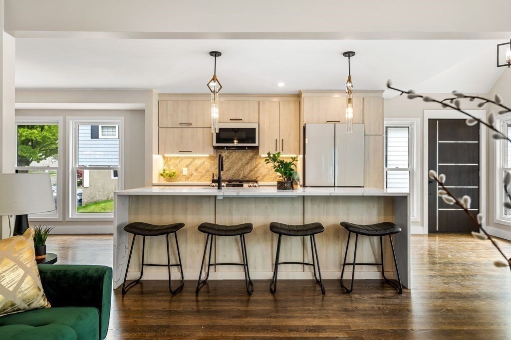 84 School Street Melrose, MA 02176 - Photo 10 of 34 a kitchen with kitchen island granite countertop a table chairs sink and cabinets