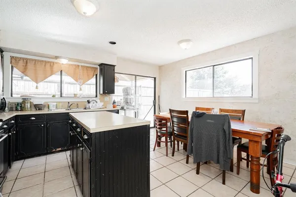 a kitchen with granite countertop a sink appliances and windows
