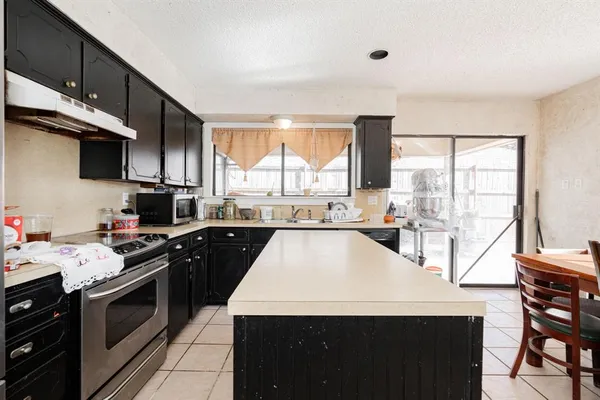 a kitchen with a sink a counter top space appliances and a window