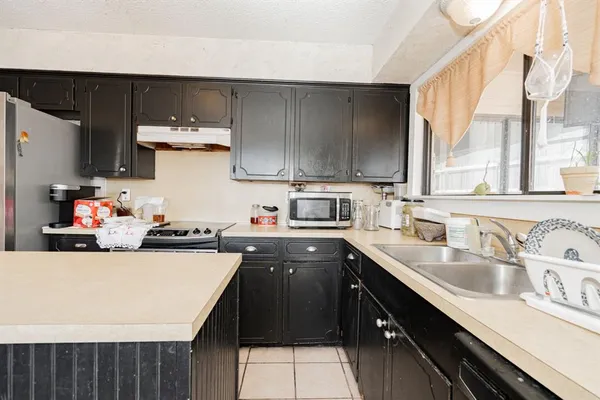 a kitchen with a sink a stove and cabinets