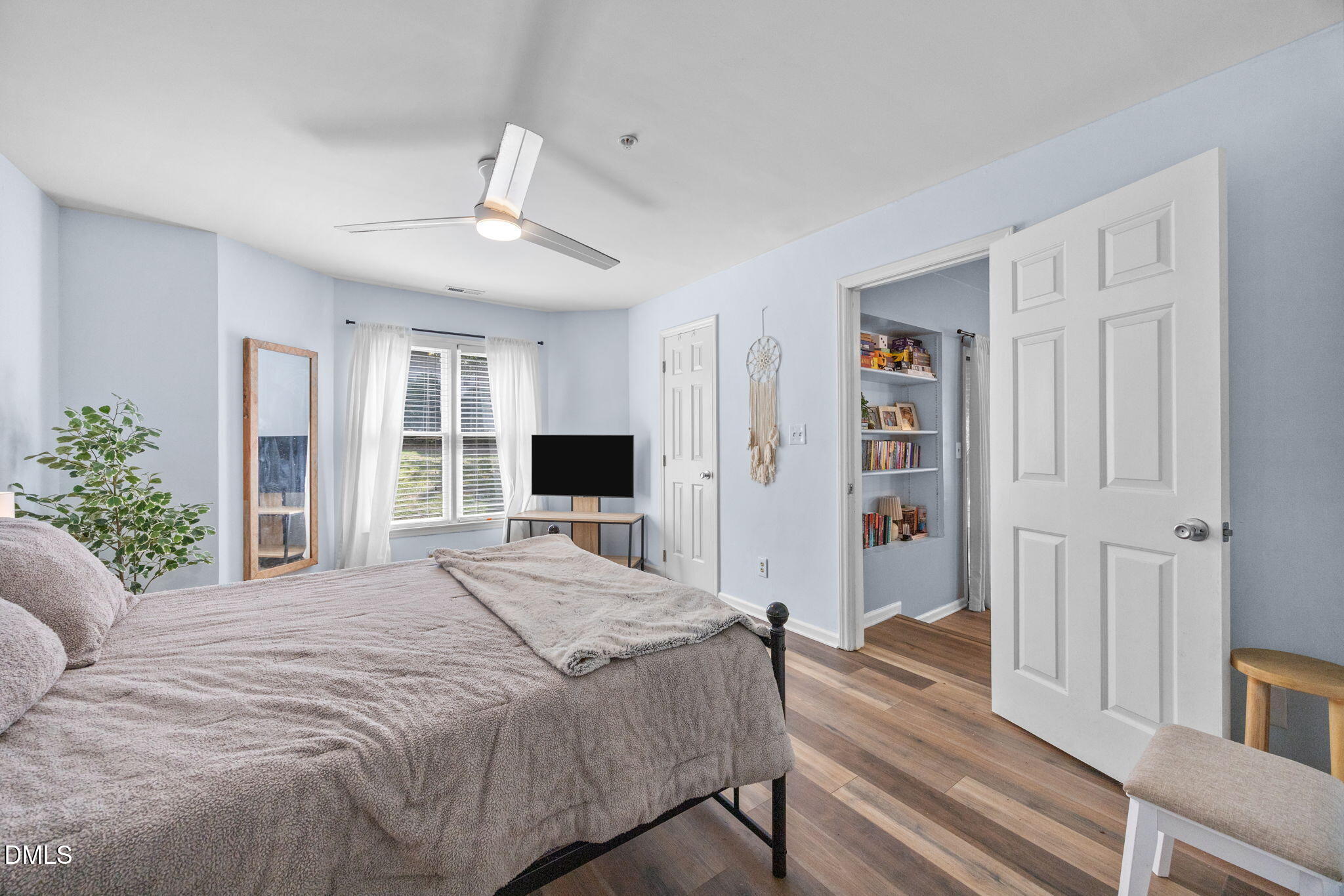 1021 Brighthurst Drive, Unit 103 Raleigh, NC 27605 - Photo 11 of 27 a bedroom with a large bed a flat tv screen and a chandelier