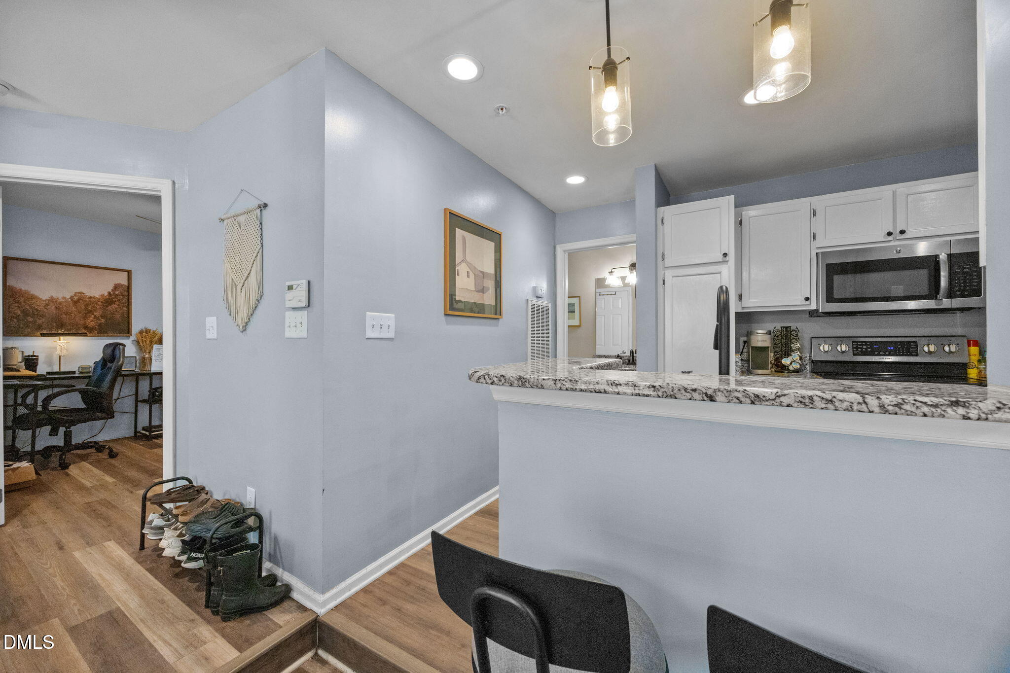 1021 Brighthurst Drive, Unit 103 Raleigh, NC 27605 - Photo 13 of 27 a kitchen with stainless steel appliances granite countertop a sink dishwasher a stove a microwave oven a refrigerator with island and chairs