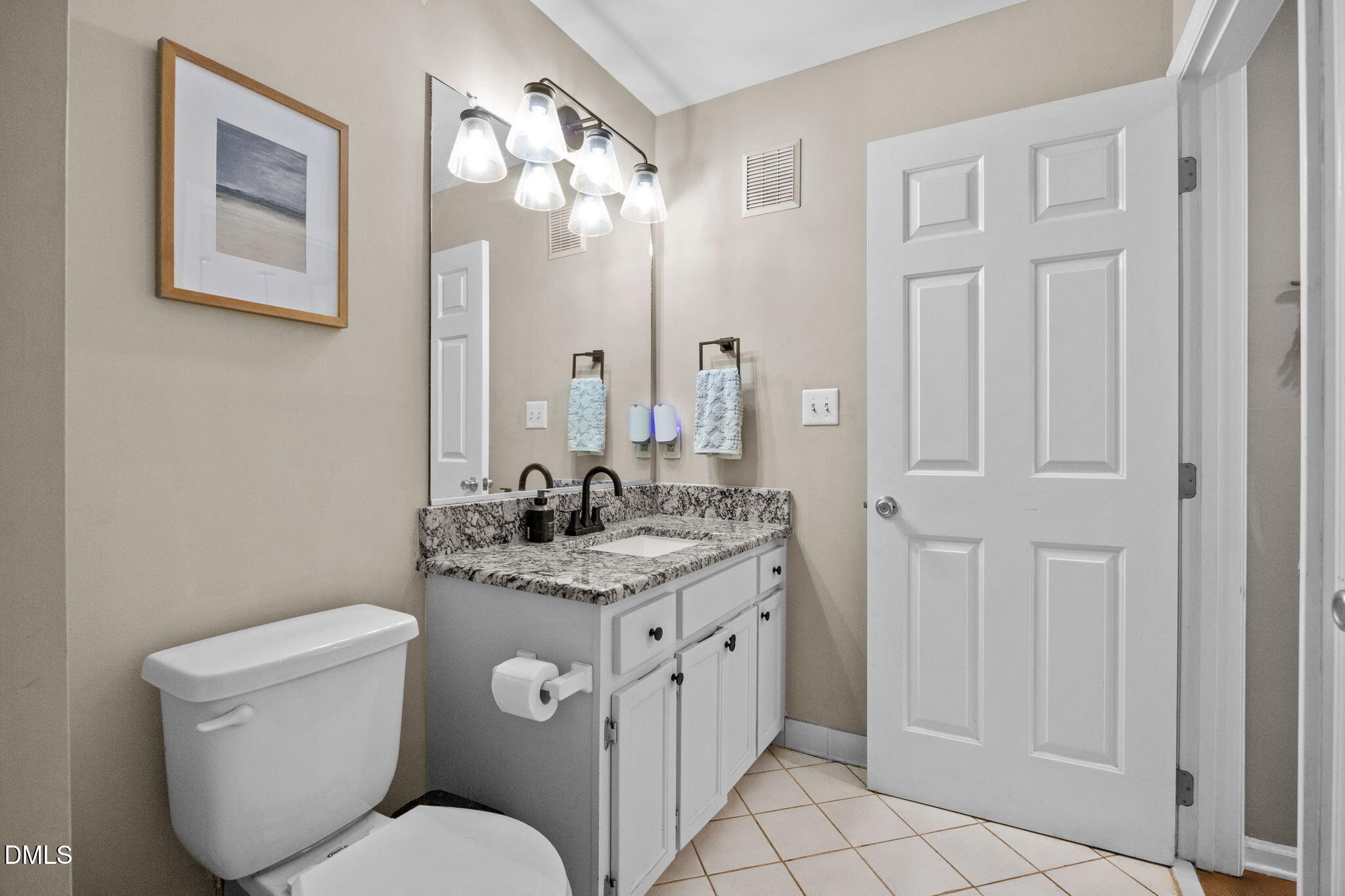1021 Brighthurst Drive, Unit 103 Raleigh, NC 27605 - Photo 18 of 27 a bathroom with a toilet a sink and mirror