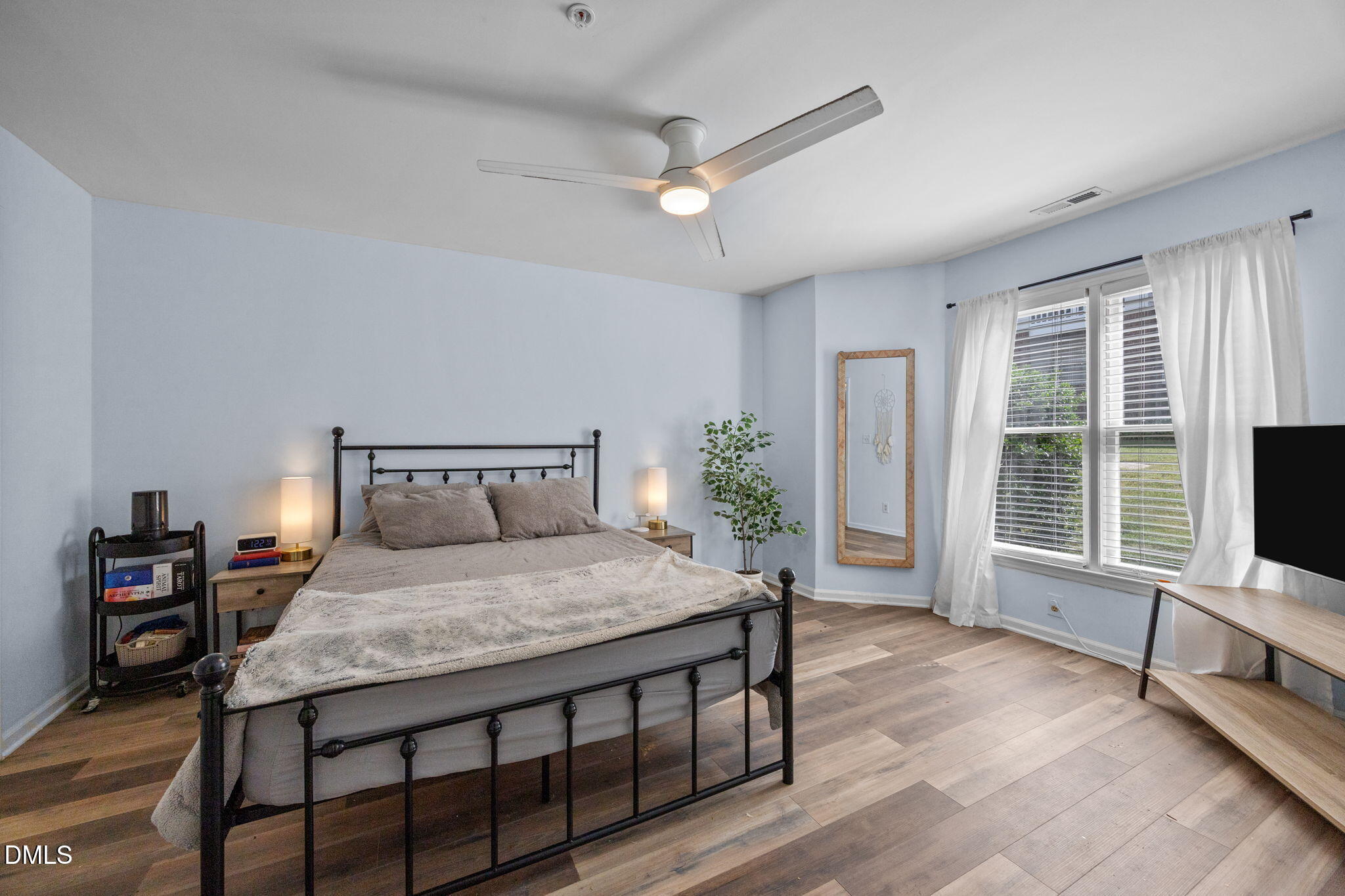 1021 Brighthurst Drive, Unit 103 Raleigh, NC 27605 - Photo 9 of 27 a bedroom with a bed a large window and flat screen tv