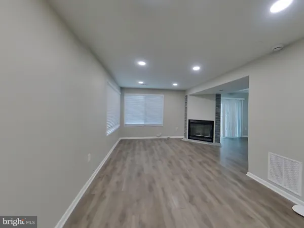 a view of empty room with wooden floor and fireplace