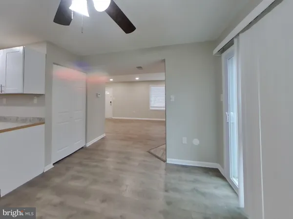 a view of an empty room and a kitchen