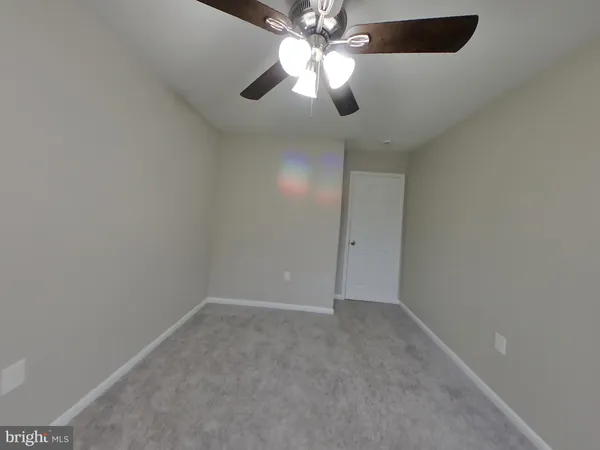 en empty room with windows and fan