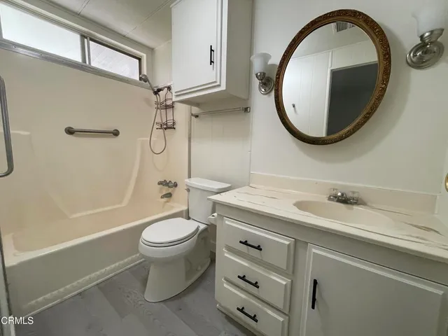 a bathroom with a granite countertop toilet a sink and a mirror