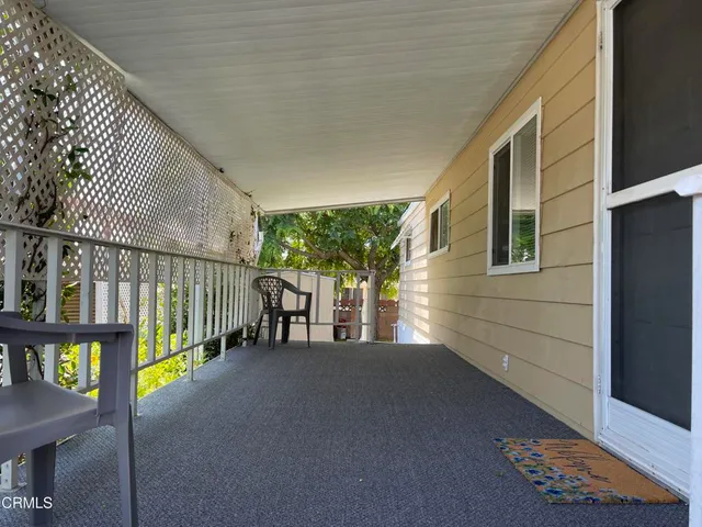a view of a porch with wooden floor and iron fence