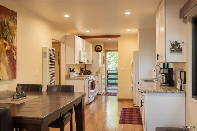 a view of a kitchen with kitchen island granite countertop a refrigerator and cabinets