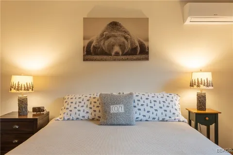 a bedroom with a bed and a lamp on dresser