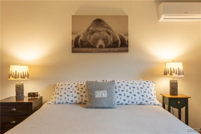 a bedroom with a bed and a lamp on dresser