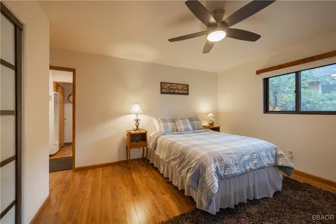 a bedroom with a bed and a ceiling fan