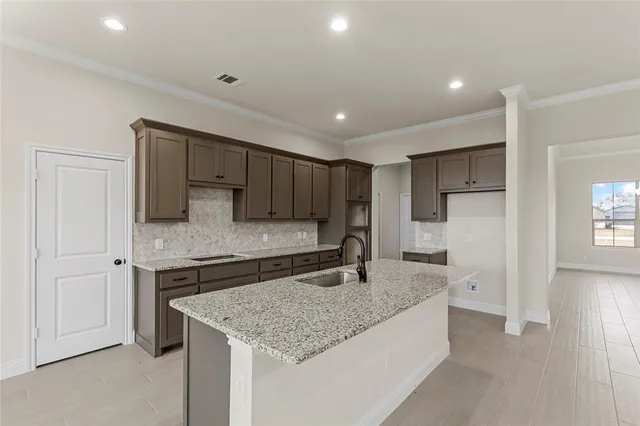 a kitchen with stainless steel appliances granite countertop a sink and a refrigerator