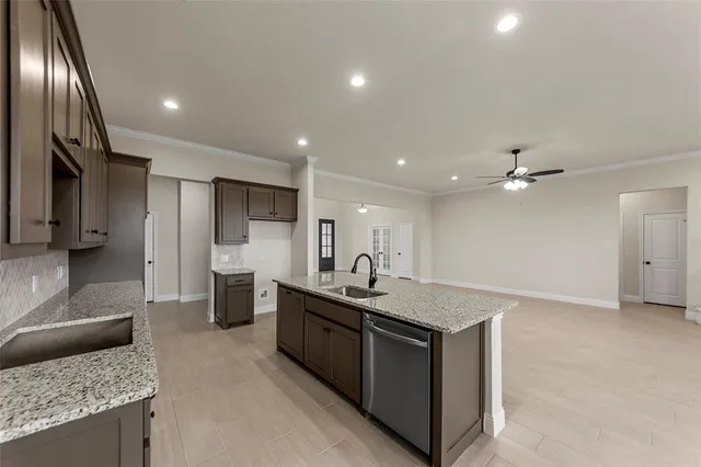 a kitchen with stainless steel appliances granite countertop a sink a stove and a refrigerator