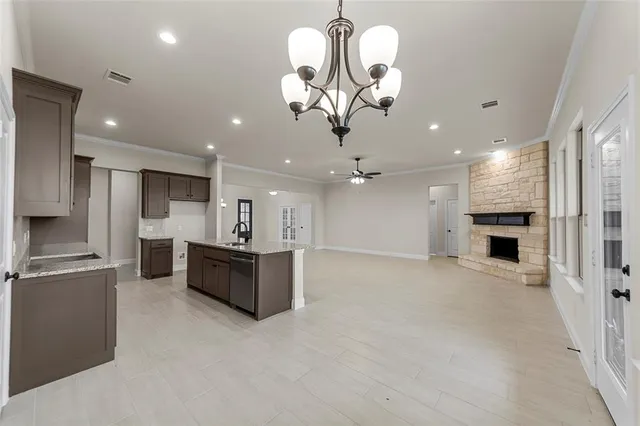 a large kitchen with a refrigerator a stove top oven a sink and dishwasher