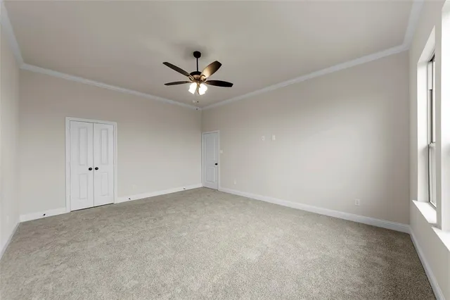 an empty room with a window and a ceiling fan