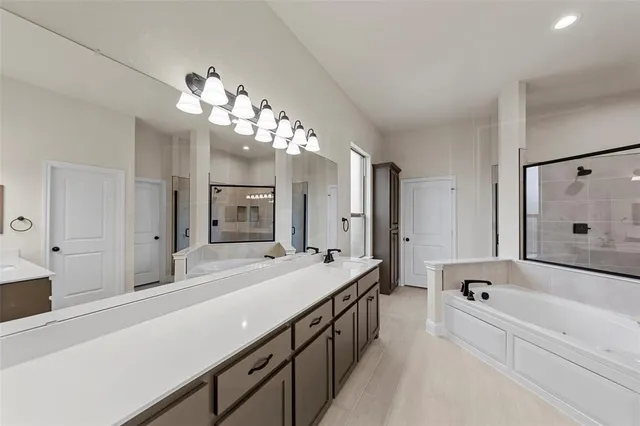 a spacious bathroom with a tub sink shower and mirror