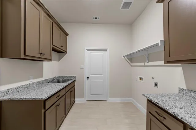 a kitchen with granite countertop a sink a stove and cabinets