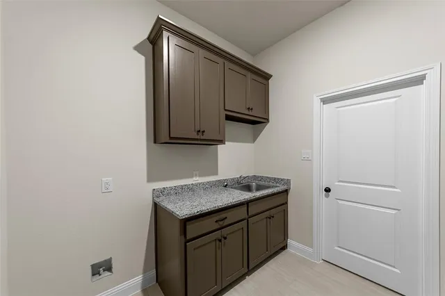 a utility room with granite countertop cabinets washer and dryer