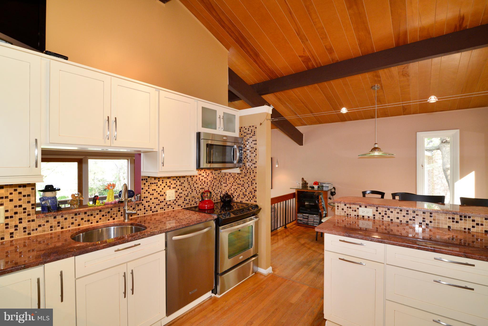 11303 South Shore Road Reston, VA 20190 - Photo 11 of 30 a kitchen with stainless steel appliances kitchen island granite countertop a sink and cabinets