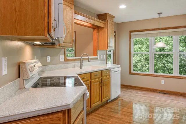 a kitchen with kitchen island a large counter top space a sink stainless steel appliances and cabinets