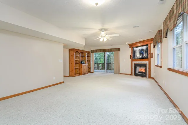 a view of an empty room with a fireplace and a window