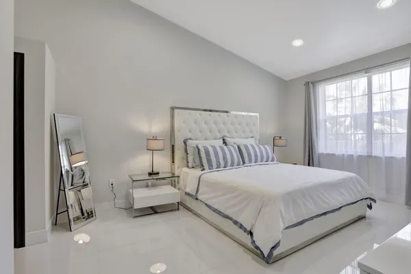 a bedroom with a bed and a large window