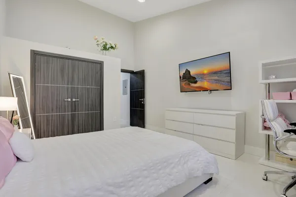 a bedroom with a bed and a flat screen tv