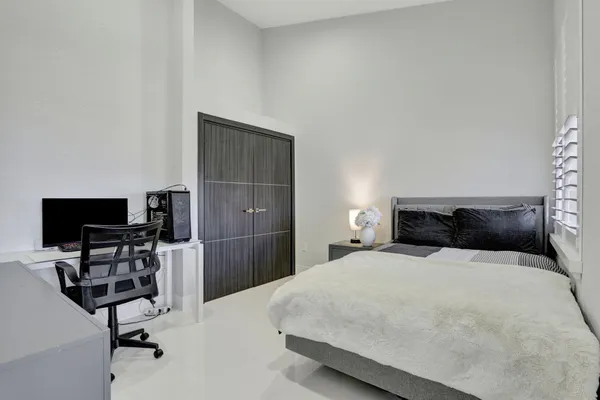 a bedroom with a bed a chair and a flat screen tv