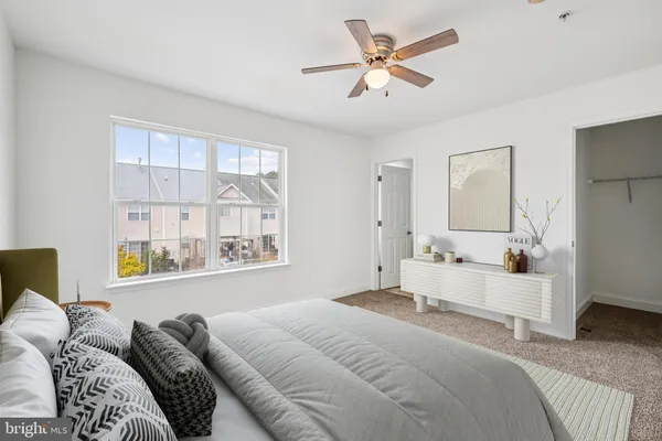 a bedroom with a large bed couch and a window