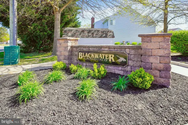 a sign that is sitting in front of flowers