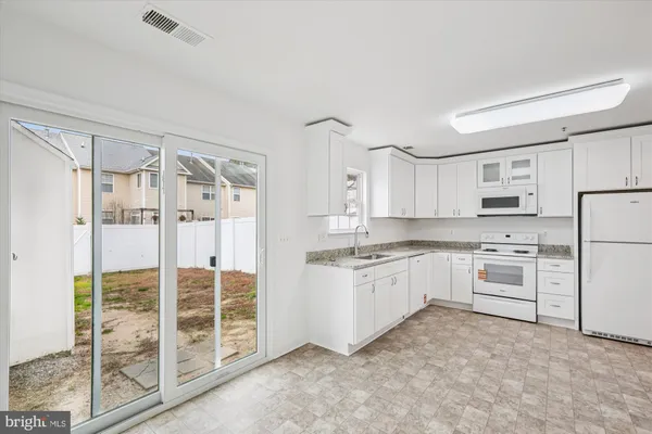 a kitchen with white cabinets and white appliances