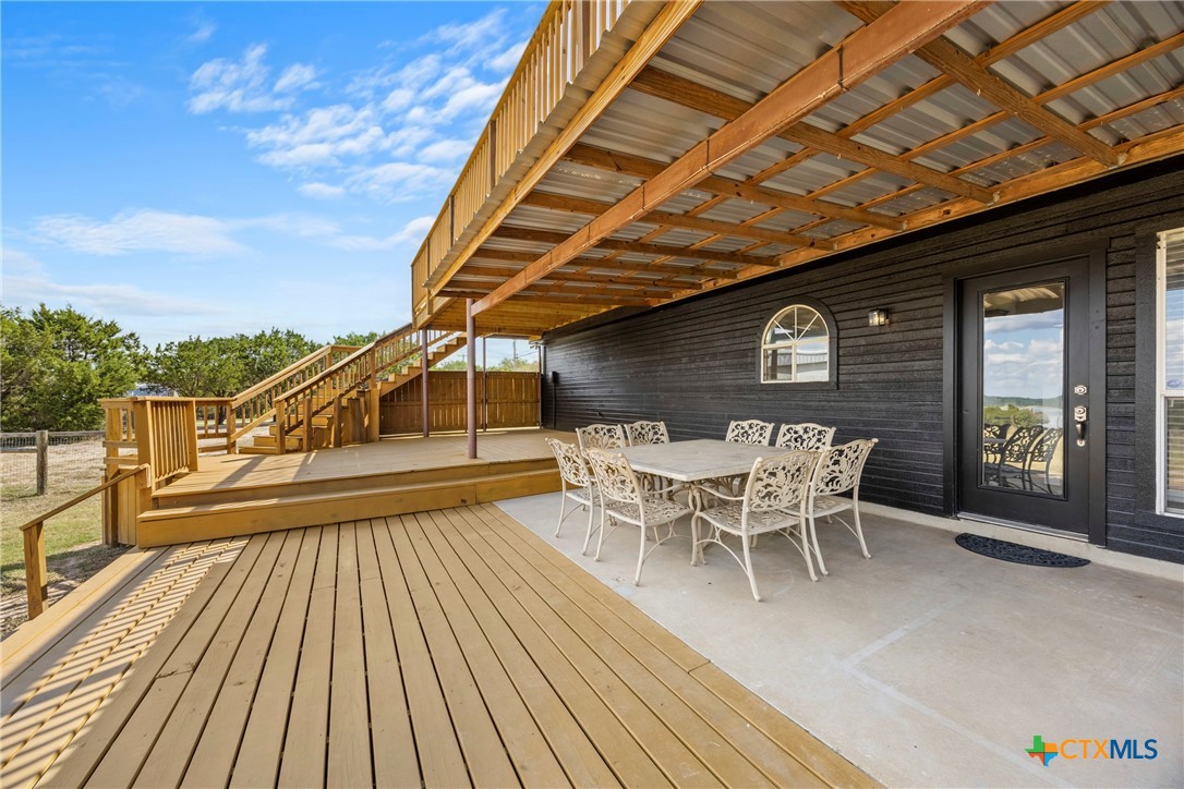 a roof deck with table and chairs and wooden floor