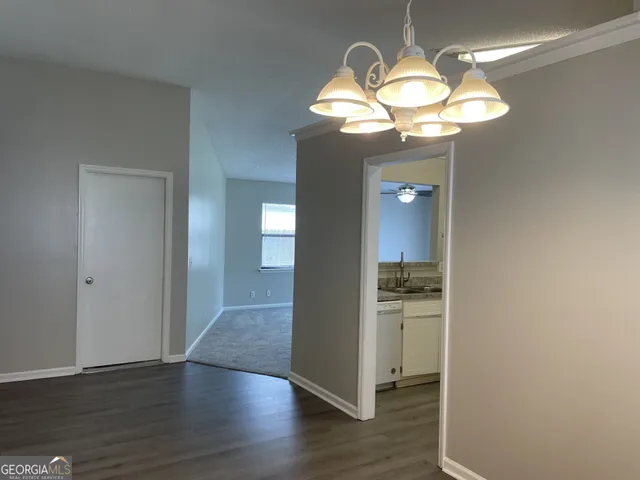 a view of a kitchen with wooden floor chandelier and entryway