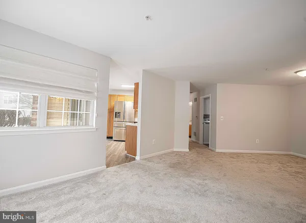 a kitchen with stainless steel appliances granite countertop a refrigerator a sink dishwasher a stove and white countertops with wooden floor