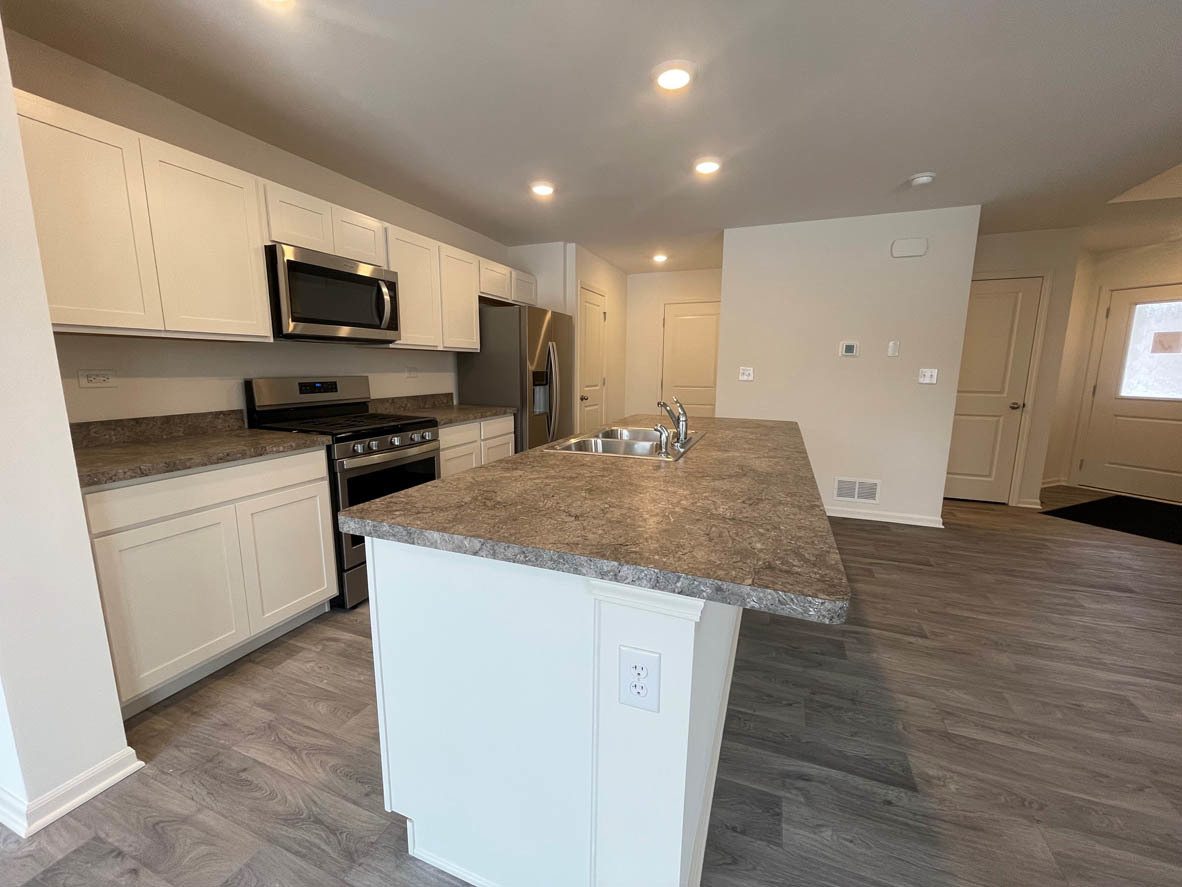 762 Westbury Drive Cary, IL 60013 - Photo 4 of 21 a kitchen with a sink a microwave and cabinets