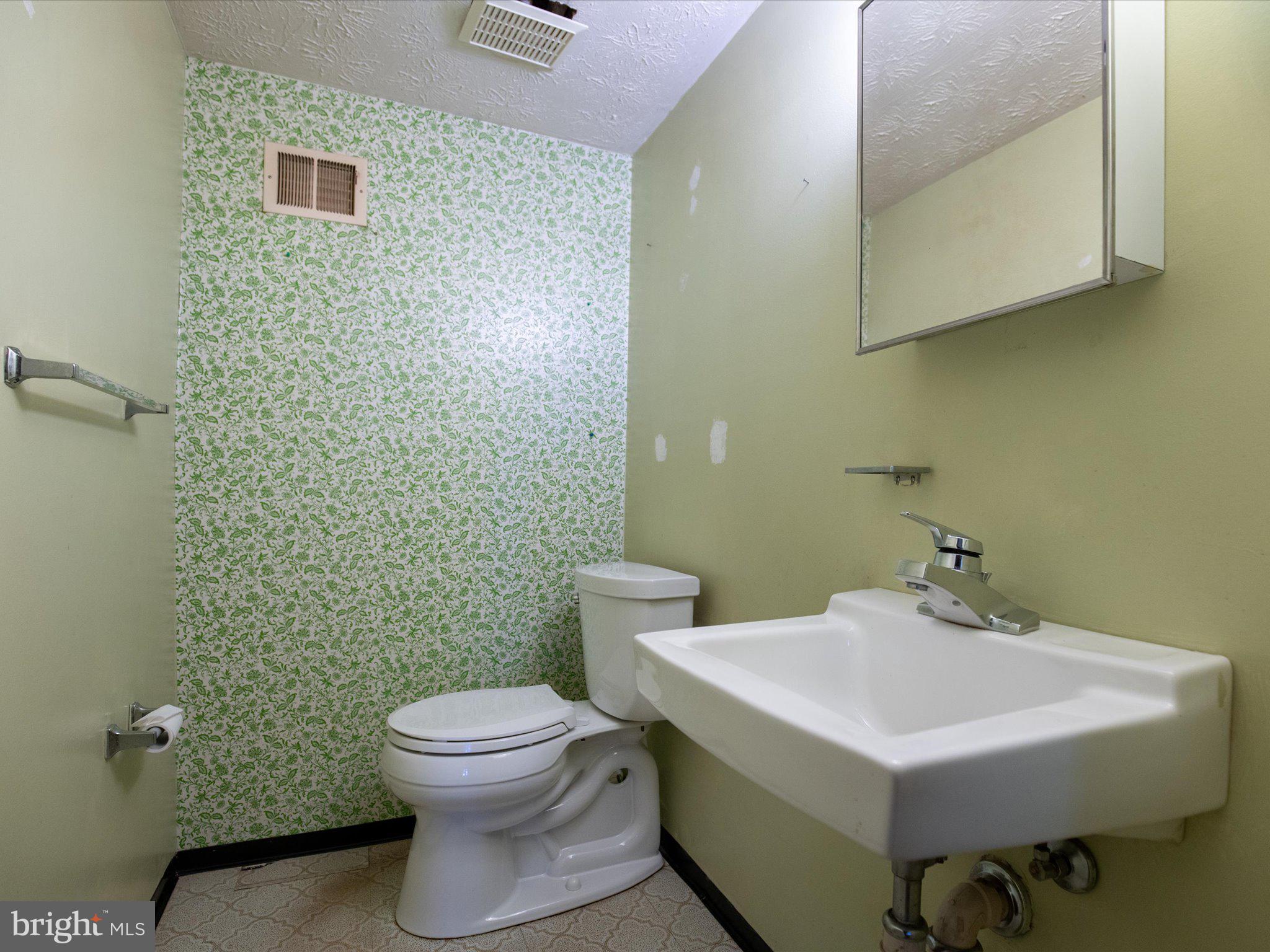 6314 West Vein Road Bowie, MD 20720 - Photo 26 of 28 a bathroom with a sink a toilet and a mirror