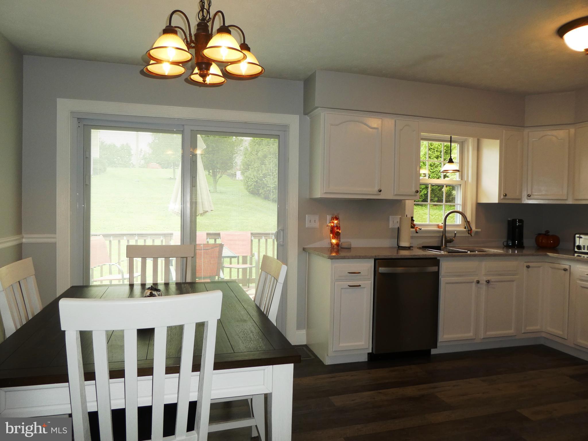 14 Springhouse Court Rising Sun, MD 21911 - Photo 3 of 13 a kitchen with cabinets wooden floor dining table and stainless steel appliances