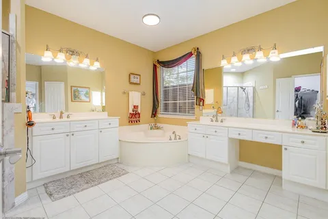 a large bathroom with a double vanity sink mirror and a bathtub