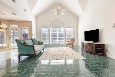 a living room with furniture a flat screen tv and a floor to ceiling window